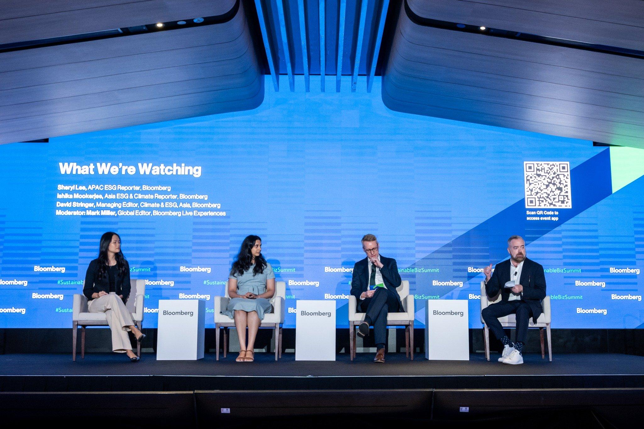 Four speakers on stage presenting during session